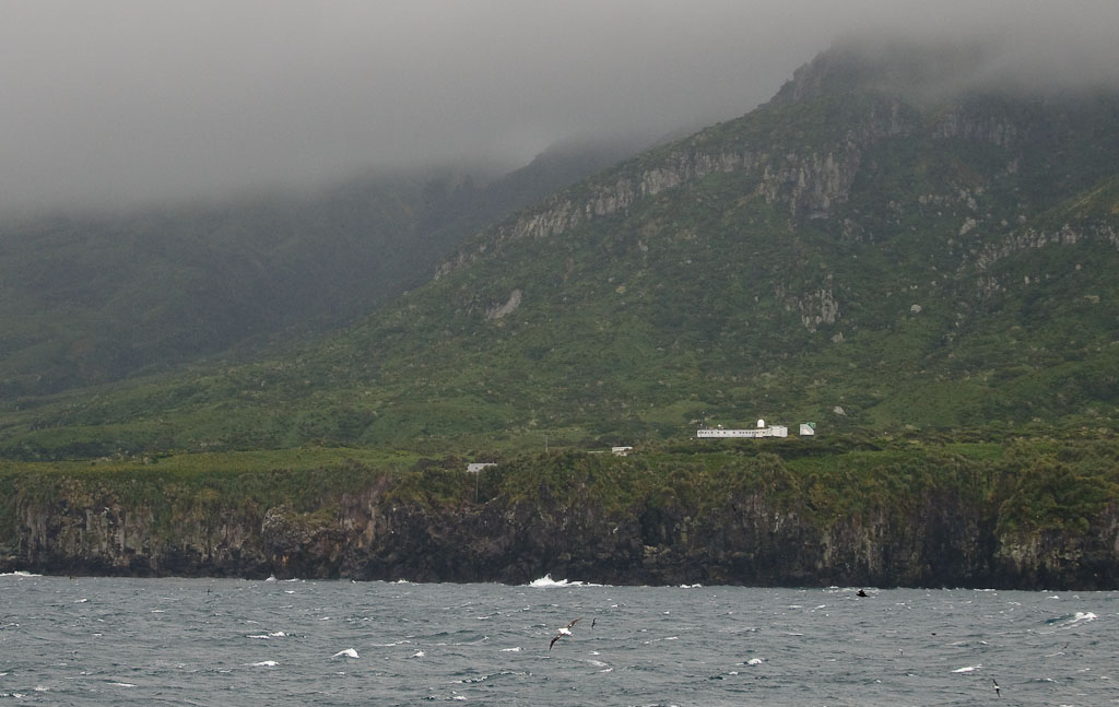  Gough Island bij aankomst met het Zuid-Afrikaanse weerstation en verschillende soorten vogels over zee. (Simon Plat)
